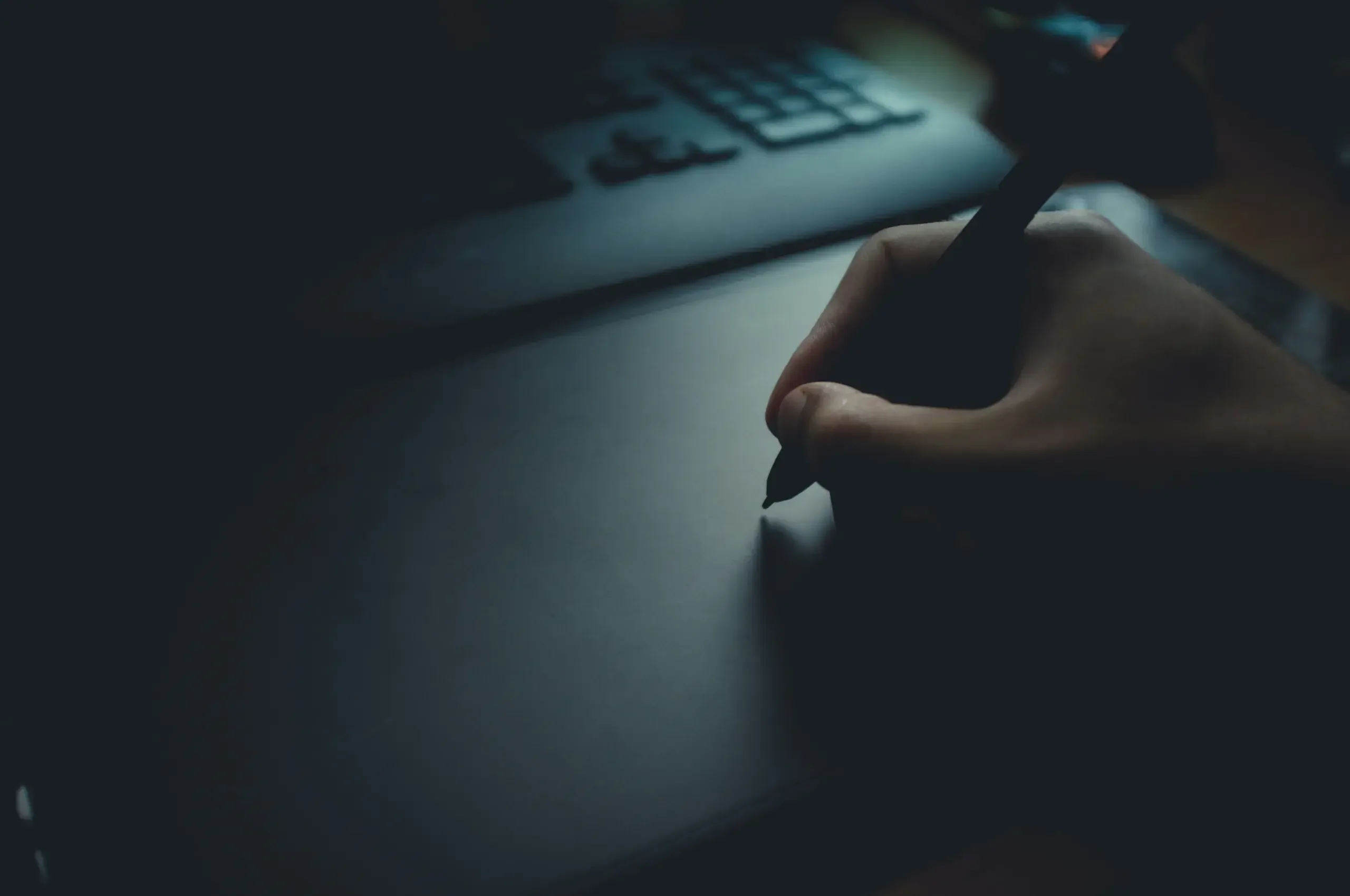Ręce na laptopie w atmosferycznym oświetleniu pracowni